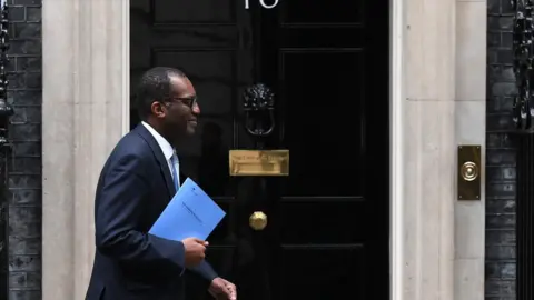 Getty Images Chancellor Kwasi Kwarteng walks past the No 10 front door