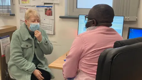 Patient Lynne Sleight being seen by a doctor