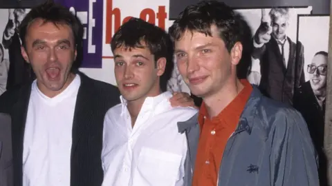 Getty Images Andrew Macdonald (right) with director Danny Boyle and actor Johnny Lee Miller at the New York premier of Trainspotting in 1996