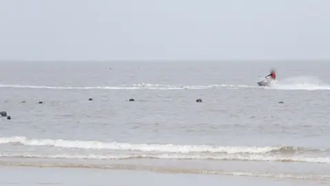 Roger Parrish/PA Wire Water scooter and seals off Horsey beach in Norfolk