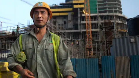 Getty Images A Chinese construction worker outside a new shopping complex building site in Colombo (2018 photo)