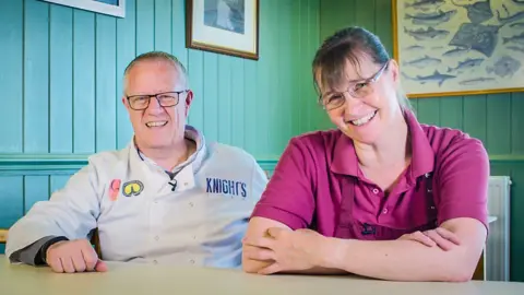 A couple from Glastonbury sat at a table.