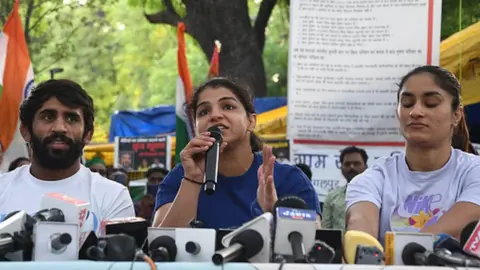 Getty Images Wrestlers Bajrang Punia, Sakshi Malik and Vinesh Phogat addressing a press conference at Jantar Mantar on May 26, 2023 in New Delhi
