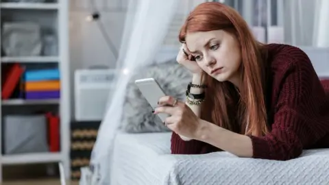 Getty Images Young woman texting