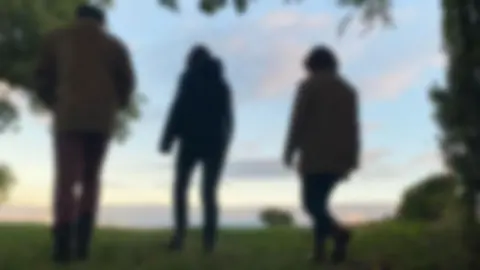 BBC Blurred shot of family-of-three
