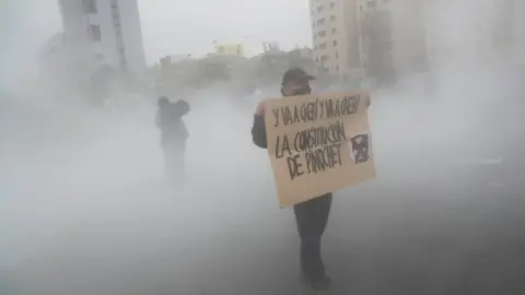 Reuters A demonstrator holds a sign during a protest against Chile"s government, in Santiago, Chile September 25, 2020