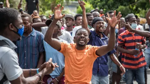 Getty Images The crowd reacts near the Police station where armed men are being detained