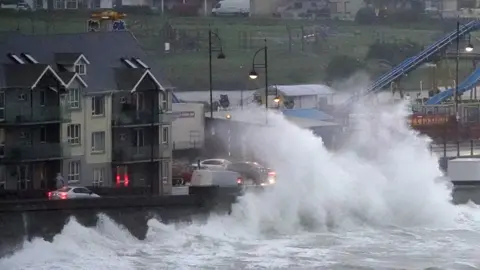 PA Media Large waves crash over the promenade in Tramore, Co Waterford.