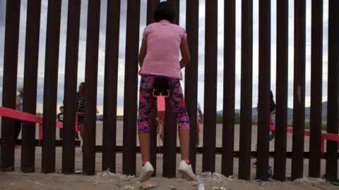 AFP Families play on seesaws at the Mexican border