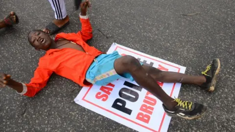 Getty Images Youths of ENDSARS protesters display their placards in a crowd in support of the ongoing protest against the harassment, killings and brutality of The Nigerian Police Force Unit called Special Anti-Robbery Squad (SARS) at Alawusa bus stop, along Lagos Ibadan-Expressway in Ikeja, on October 13, 2020