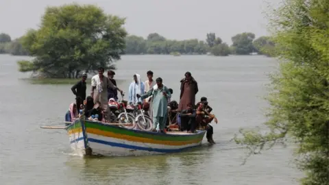 Reuters Residents use boat to travel amid flood water, following rains and floods during the monsoon season in Sehwan, Pakistan September 14, 2022.