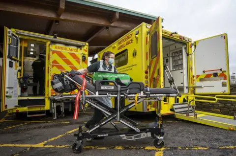 PA Media A paramedic working next to two ambulances