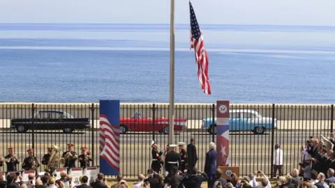 Reuters US marines raise the US flag while watched over by US Secretary of State John Kerry (C, at lectern, back to camera) at the US embassy in Havana, Cuba, August 14, 2015