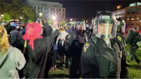 Reuters Police in riot gear, protesters holding phones