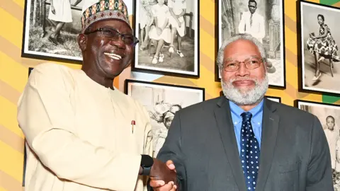 Getty Images Dr Abba Isa Tijani, Nigerian professor of museology and anthropology, shakes hands with Lonnie G Bunch III, secretary of the Smithsonian Institution, at the Benin Bronzes repatriation ceremony and reception at the National Museum of African Art on 11 October 2022 in Washington DC, the US