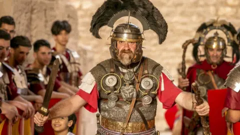 Yassine Gaidi/Getty Images People wearing clothing from Roman Empire period perform within the "Rome Days" Festival at the Amphitheatre of El Djem in Mahdia Governorate south of Tunis, Tunisia - Sunday 30 April 2023