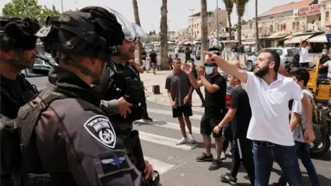 Reuters Palestinian man gestures to Israeli police in Jerusalem (10/05/21)