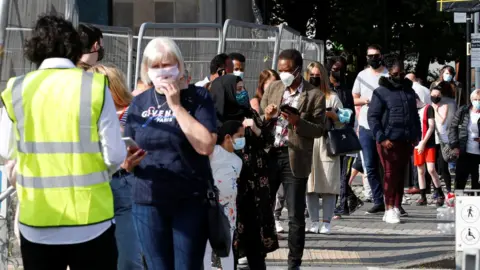 Reuters People queuing to get vaccinated in Bolton