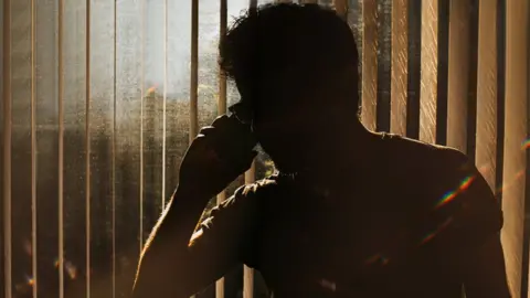 Getty Images A man in silhouette on the phone