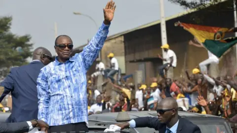 Getty Images Alpha Conde greets his supporters in Conakry (archive shot)