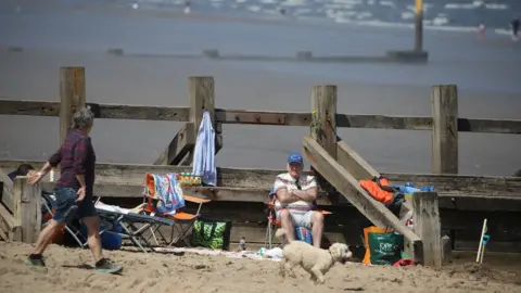 PA Media People enjoy the good weather at Portobello beach, near Edinburgh on Bank Holiday Monday