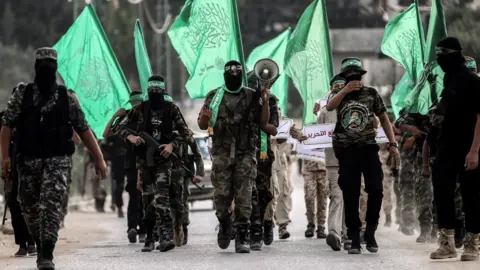 AFP Members of the Hamas military wing, the Izzeddine al-Qassam Brigades, march in the southern Gaza Strip (15 September 2017)