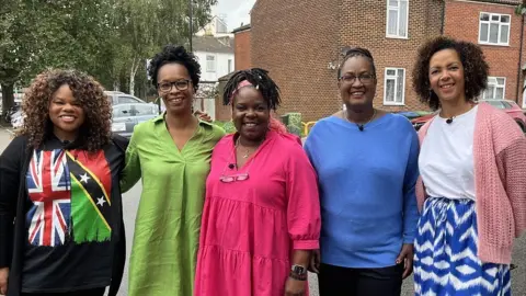 BBC five women stand in a line and hug each other