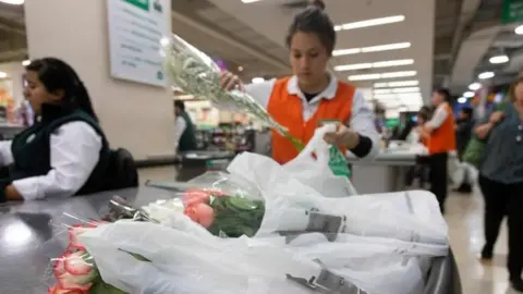 AFP Un dependiente coloca los artículos de los clientes en una bolsa de plástico en un supermercado de Santiago, el 18 de julio de 2018.