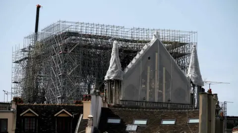 AFP The Rosette of Notre-Dame de Paris Cathedral in Paris on April 22, 2019, is covered with protective material, seven days after a fire devastated the cathedral.