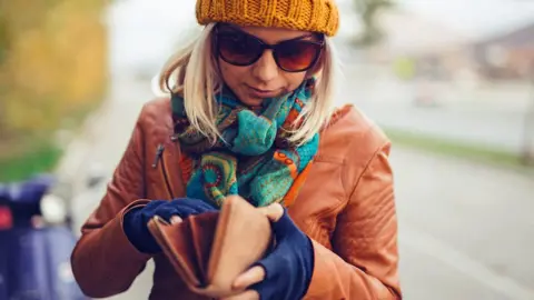 Getty Images Woman looking in wallet