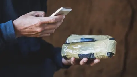 Getty Images Drug dealer using a phone