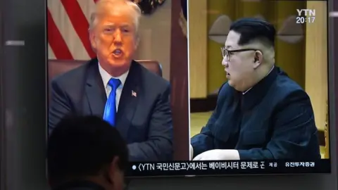 AFP A South Korean news show broadcasts images of Donald Trump and Kim Jong-un side by side