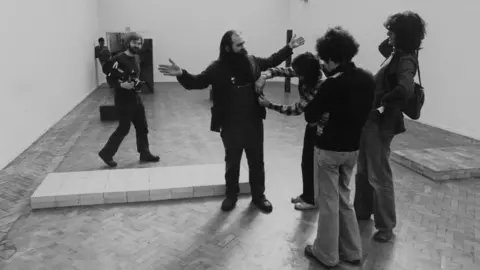 Getty Images Carl Andre with his controversial "pile of bricks" sculpture at London's Tate gallery in 1976