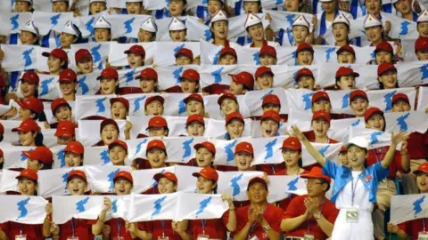 EPA North Korean cheerleaders holding the "unified Korea" flag in 2003