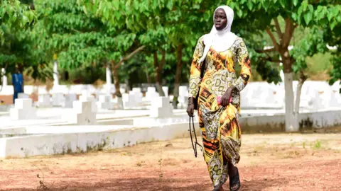 AFP/Getty Images A Senegalese woman walks past graves as family and friends visit to mark the 15th anniversary of the sinking of the ship 'Le Joola'