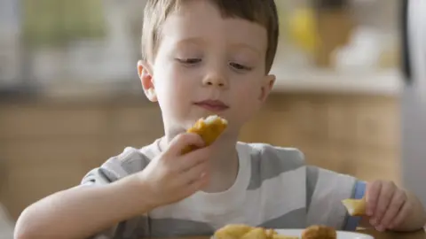 Getty/Jose Luis Pelaez Inc boy eating chicken nuggets -