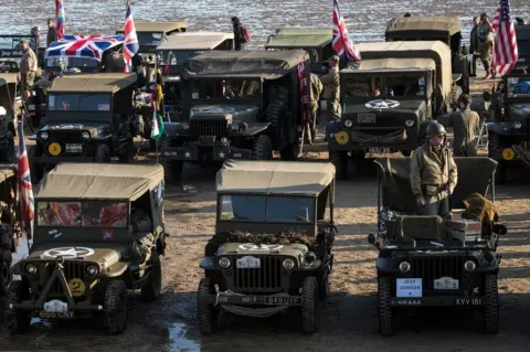 Getty Images Period vehicles on the beach of Arromanches