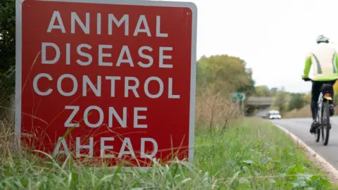 Joe Giddens/PA Wire Animal disease control zone sign