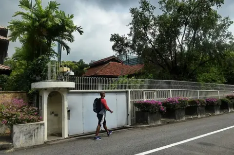AFP/Getty Images A man walks past the house of Singapore's late founding father Lee Kuan Yew at Oxley Rise in Singapore on 11 April 2016.