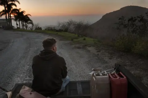 Don Bartletti/BBC Kase Dietrich sits on the tailgate of Brayden's 91 Chevy pickup, near Oceanside, LA