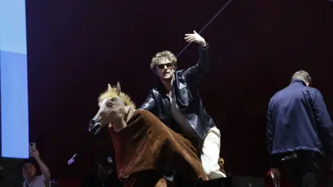 Tom Grennan on a pantomime horse