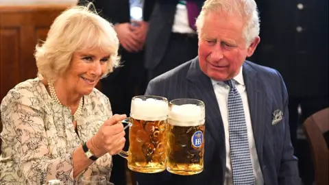 Getty Images Camilla and Charles holding steins of beer in Germany in 2019