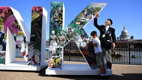 EPA Edd Mortimer, 85, from the Royal Service Corps writes a message along with a school child during the Royal Legion"s "Thank You" campaign