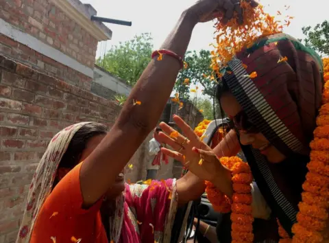 BBC A supporter throws marigold petals at Mahua Moitra