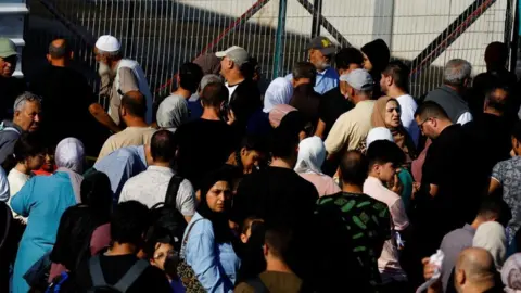 Reuters Palestinians with dual citizenship gather outside Rafah border crossing with Egypt - 16 October 2023