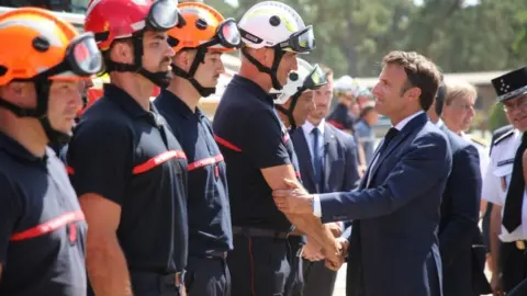 EPA Emmanuel Macron greets firefighters at field command post in La Test-de-Buch