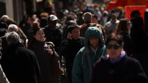Getty Images Pedestrians walk down a city street in New York City on 25 March 2011
