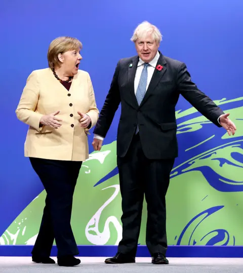 EPA Prime Minister Boris Johnson (right) greets German Chancellor Angela Merkel at the COP26 UN Climate Change Conference in Glasgow, 1 November 2021.