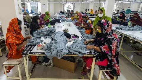 MUNIR UZ ZAMAN Labourers work in a garment factory during a government-imposed lockdown as a preventative measure against the spread of the Covid-19 in Asulia on 7 April 7 2020.