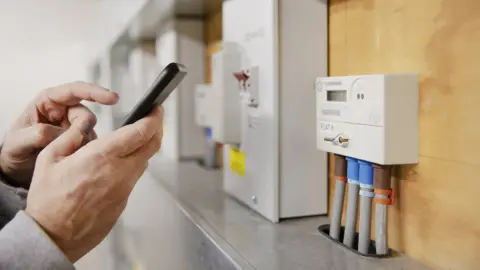 Getty Images Person taking electricity meter reading on their smart phone